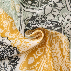 Close-up of lightweight cotton linen scarf featuring green ethnic patterns and fine textures