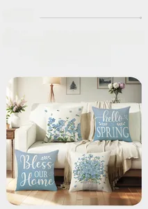 Close-up of four spring floral pillow covers with blue flower patterns on a soft sofa