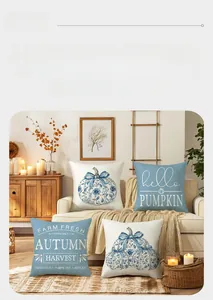 Detail of four fall harvest pumpkin pillow covers with blue floral patterns on sofa