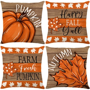 Set of four autumn pumpkin and maple leaf printed pillow covers on rustic wood background