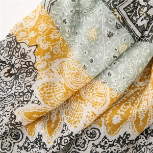 Close-up of lightweight paisley printed scarf with yellow and green ethnic patterns