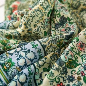 Detailed macro view of soft linen scarf fabric with green bohemian floral prints
