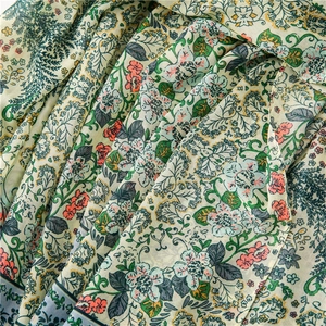 Detail of soft cotton linen fabric featuring vintage green floral and botanical prints
