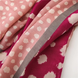 Détail macro de la texture sergée avec pois roses et motifs géométriques