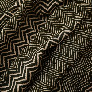 Macro shot of dark green and beige herringbone knit fabric with a soft texture