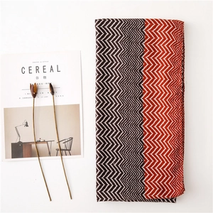 Zigzag pattern knitted scarf in brown and orange tones, flat lay with cereal magazine