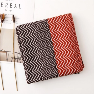 Macro view of zigzag knit scarf with deep brown and orange-red geometric patterns