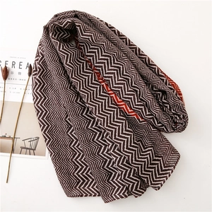Brown and white zigzag patterned scarf styled with lifestyle decor for a cozy look