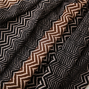Detailed close-up of zigzag patterned fabric in black, white, and brown shades