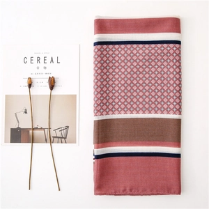 Detail of red geometric striped linen scarf with small diamond patterns and fringe