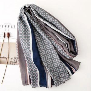 Flat lay of a breathable linen-feel scarf with grey diamond patterns and blue striped edges