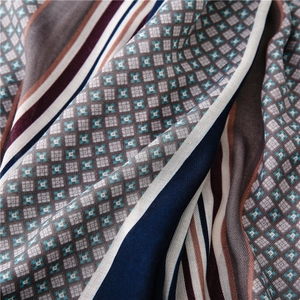 Detail shot of cotton linen scarf texture featuring geometric patterns and striped design
