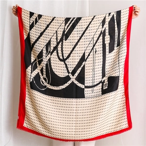 Detail of dots and chain pattern scarf with red borders and fringe tassels