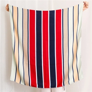 Detailed close-up of a large multicolor striped scarf featuring red, navy, and white blocks