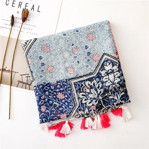 Detail of floral printed scarf with pink tassels and cotton-linen texture