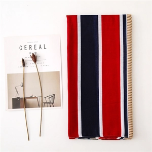 Close-up of classic British style red and navy striped scarf on a minimalist background