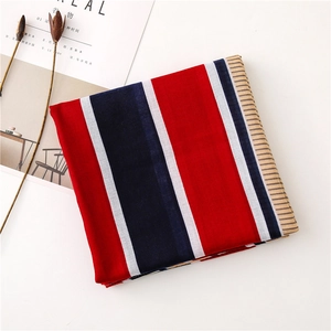Folded striped scarf with red navy and white bands displayed next to dried flowers