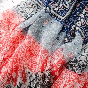 Detail of red paisley and blue floral print on lightweight bohemian cotton scarf fabric