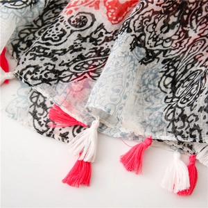 Detail of floral printed sun shawl with pink cotton tassels and ethnic pattern