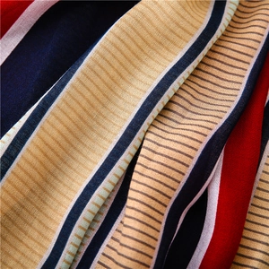 Macro detail of striped chiffon fabric showing red, navy, and purple patterns