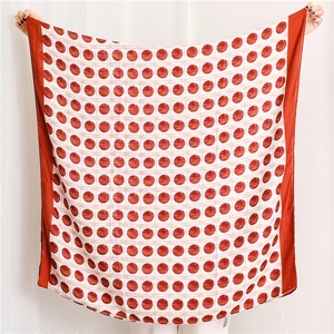 Detail of a large square scarf featuring classic red and white polka dots and a wide red border
