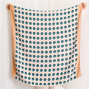 Large square lightweight scarf featuring a blue polka dot pattern and tan colored borders