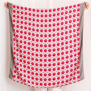 Detail of red polka dot scarf with white grid pattern and gray border edges