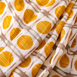 Macro view of lightweight yellow polka dot and brown checked fabric scarf texture