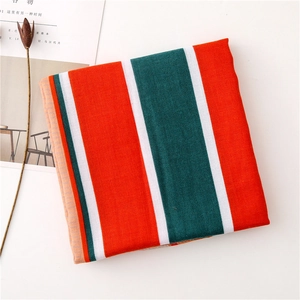 Detail of orange and green striped thick shawl fabric with a textured woven finish