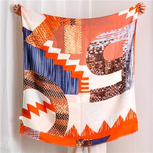 Detailed flat lay of large scarf with modern orange and navy blue geometric abstract prints