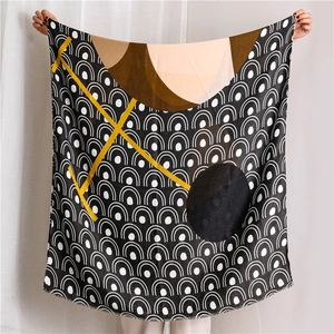 Detail of artistic scarf showing yellow geometric lines over black and white wavy patterns