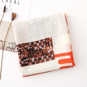 Flat lay of a lightweight cotton-linen square scarf with modern geometric color blocks