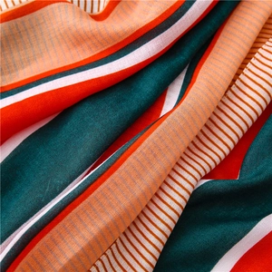 Macro shot of striped textile showing texture in dark green, bright orange and white