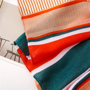 Detailed macro shot of striped cotton scarf with orange and green geometric patterns