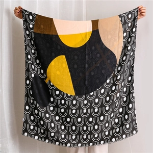 Detail view of large scarf with geometric abstract patterns and delicate frayed edges