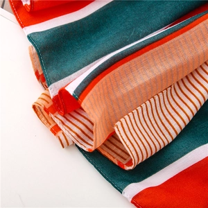 Macro shot of striped chiffon fabric with fine red, white, and green patterns and hemmed edges