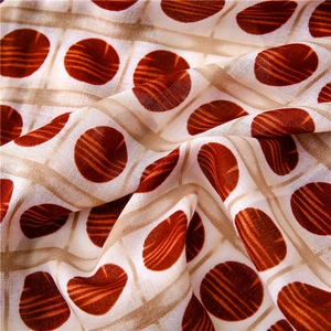 Macro shot of lightweight beige scarf fabric featuring red striped polka dot patterns