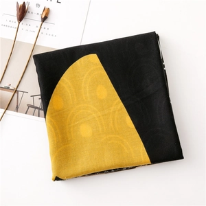 Folded yellow and black scarf with concentric circle patterns and textile texture