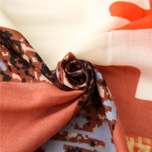 Macro detail of geometric pixel pattern and woven texture on a silk-like scarf