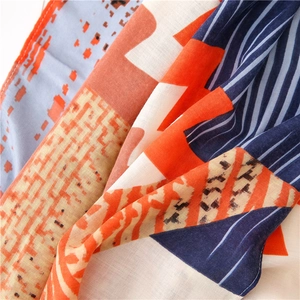 Detailed macro view of geometric cotton linen scarf with vibrant orange and navy patterns
