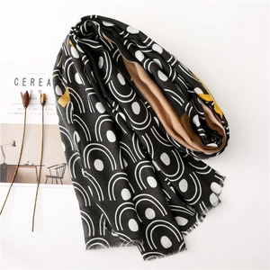 Black and white geometric pattern scarf with mustard yellow accents and frayed edges