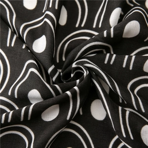Macro shot of soft black fabric with white abstract geometric patterns and texture details