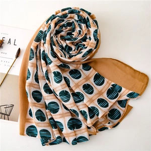 Elegant caramel plaid chiffon scarf with green dots shown in a flat lay spiral arrangement