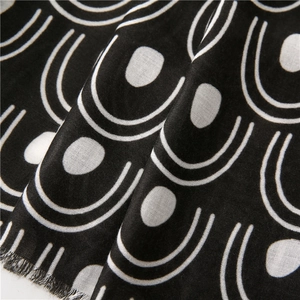Macro detail of geometric black and white woven fabric with fringe and U-shaped pattern
