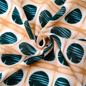 Detailed close-up of light beige fabric with green circular ripples and soft drape texture