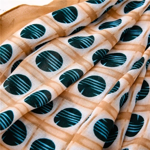 Detailed close-up showing the soft texture and blue circular pattern on a brown scarf
