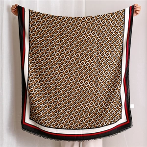 Détails macro d'une écharpe à monogramme avec franges et bordure à rayures rouges