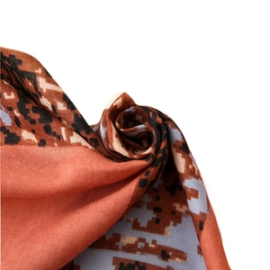 Digital pixel leopard print fabric in orange and brown with smooth satin texture