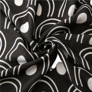 Close-up of black and white abstract arc print fabric with a soft woven texture