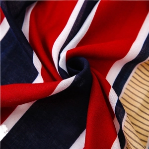 Vibrant red, blue and white striped fabric with soft draped texture in a macro shot